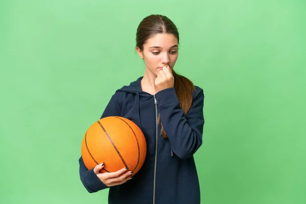ティーンCaucasian女の子遊びバスケットボール上の隔離された背景持っています疑問 — ストック写真