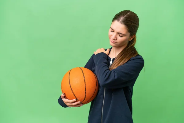 若いですCaucasian女の子プレイバスケットボール上の隔離された背景苦痛で肩のために努力した — ストック写真