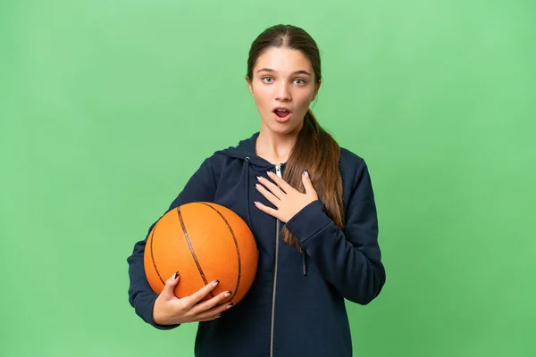 ティーンCaucasian女の子プレイバスケットボール上の隔離された背景驚きとショックを与えながら見ます右 — ストック写真