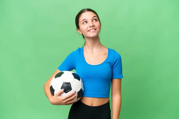Teenager Caucasian Girl Playing Football Isolated Background Looking While Smiling — Stock Photo, Image