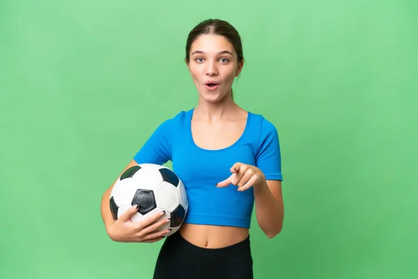 Nastolatek Kaukaski Dziewczyna Gra Piłkę Nożną Odosobnione Tło Zaskoczony Wskazując — Zdjęcie stockowe
