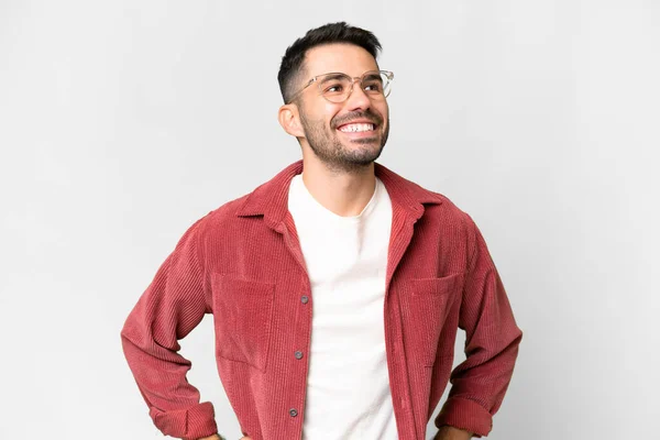 stock image Young handsome caucasian man over isolated white background posing with arms at hip and smiling