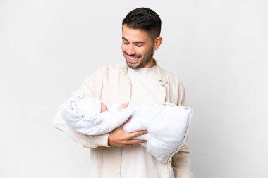 Yeni doğmuş bebeğiyle genç beyaz bir baba izole edilmiş bir arka planda mutlu bir ifadeyle.