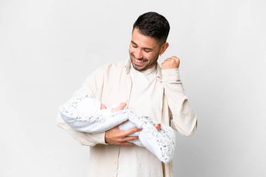 Yeni doğmuş bebeğiyle birlikte genç beyaz bir baba izole bir arka planda zaferi kutluyor.