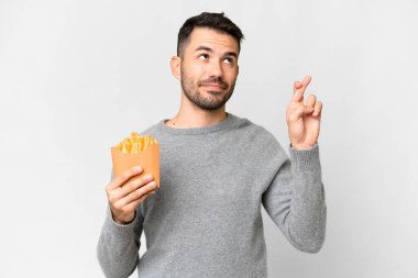 Kafkasyalı genç adam izole edilmiş beyaz arka planda patates kızartması tutuyor ve şans diliyor.