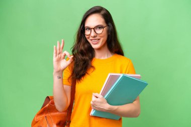 Young student caucasian woman over isolated background showing ok sign with fingers