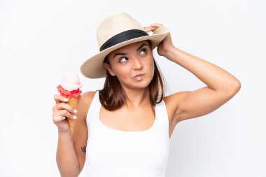 Young caucasian woman with a cornet ice cream isolated on white background having doubts and with confuse face expression