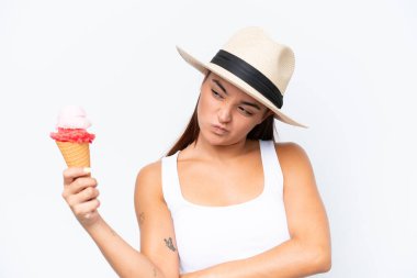Young caucasian woman with a cornet ice cream isolated on white background with sad expression