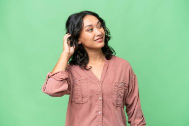 Arjantinli genç bir kadın izole edilmiş bir arka plan düşünüyor.