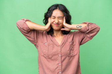 Arjantinli genç bir kadın izole edilmiş arka planda hayal kırıklığına uğramış ve kulaklarını kapatmış