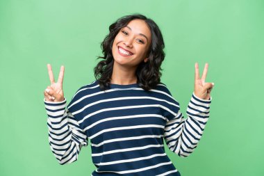 Arjantinli genç bir kadın iki eliyle zafer işareti gösteriyor.