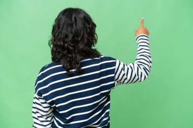 Arjantinli genç bir kadın izole edilmiş arka planda işaret parmağıyla işaret ediyor.