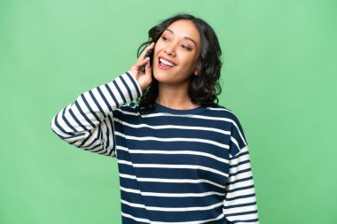 Arjantinli genç bir kadın izole edilmiş arka planda cep telefonuyla sohbet ediyor.