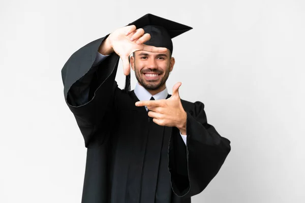 Jonge Afgestudeerde Man Met Een Geïsoleerde Witte Achtergrond Framing Symbool — Stockfoto