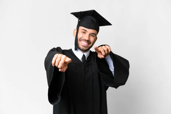 Молодий Випускник Університету Над Ізольованим Білим Фоном Вказує Пальцем Посміхаючись — стокове фото