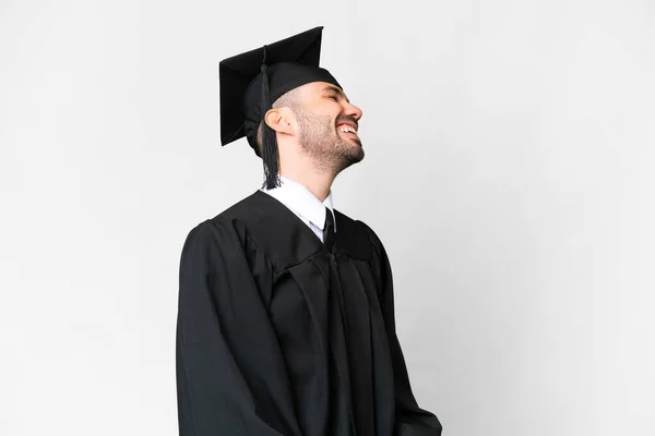 Junger Universitätsabsolvent Lacht Über Isolierten Weißen Hintergrund Seitenlage — Stockfoto