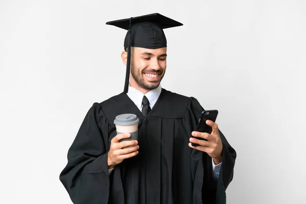 Junger Universitätsabsolvent Vor Isoliertem Weißen Hintergrund Mit Kaffee Zum Mitnehmen — Stockfoto