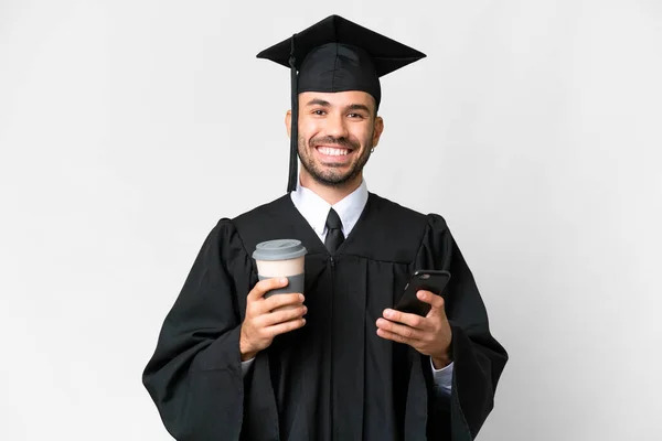 Νεαρός Απόφοιτος Πανεπιστημίου Πάνω Από Απομονωμένο Λευκό Φόντο Κρατώντας Καφέ — Φωτογραφία Αρχείου