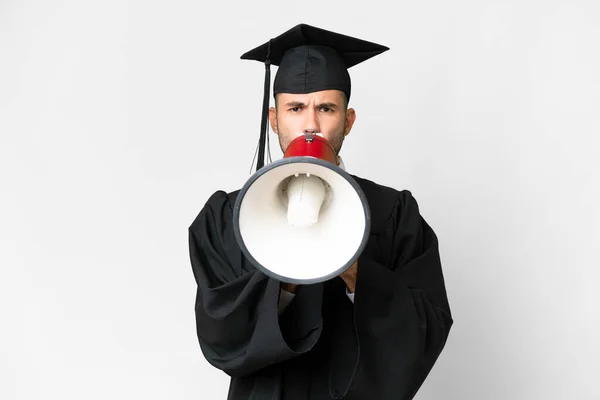 Молодий Випускник Університету Над Ізольованим Білим Тлом Кричить Через Мегафон — стокове фото
