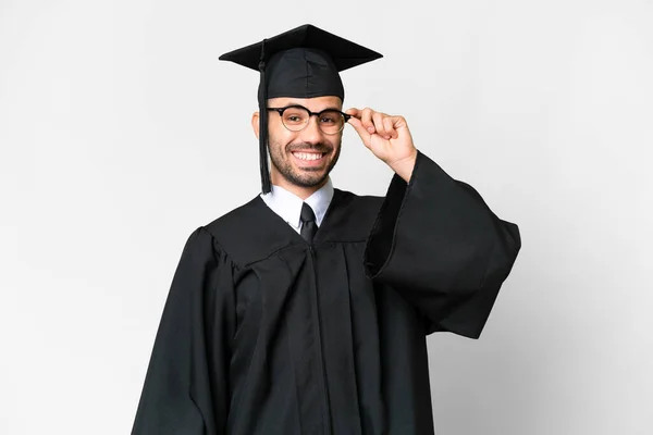Jonge Afgestudeerde Man Geïsoleerde Witte Achtergrond Met Bril Verrast — Stockfoto