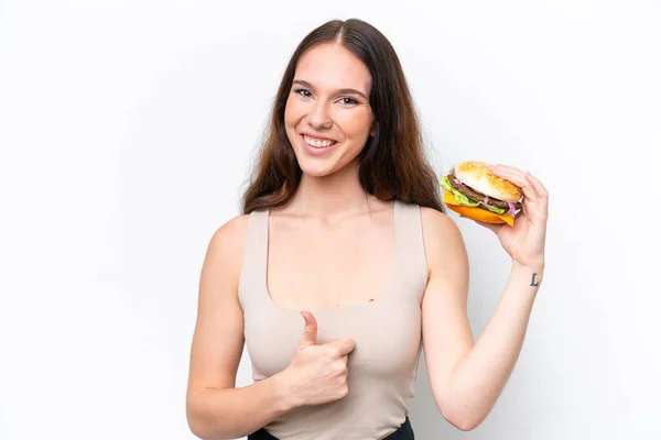 Mujer Caucásica Joven Sosteniendo Una Hamburguesa Aislada Sobre Fondo Blanco — Foto de Stock