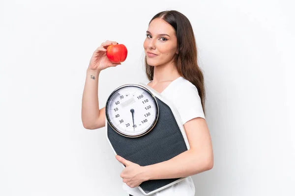 年轻的高加索女人 背靠白色的背景 带着度量衡和一个苹果 — 图库照片