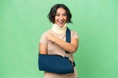 Arjantinli genç bir kadın boyunluk takıyor ve izole bir arkaplanda zafer kutlaması yapıyor.