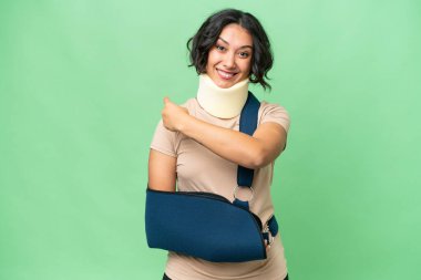 Arjantinli genç bir kadın boyunluk takıyor ve izole edilmiş arka planda asılı duruyor.