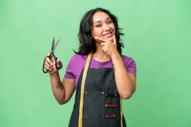 Genç terzi Arjantinli kadın izole edilmiş arka planda mutlu ve gülümsüyor