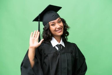 Genç üniversite mezunu Arjantinli kadın mutlu bir ifadeyle selâm veriyor.