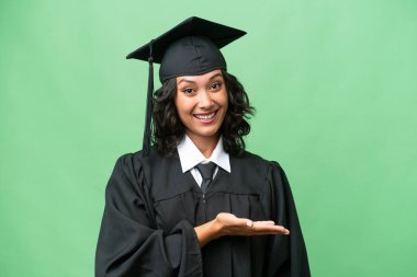 Genç üniversite mezunu Arjantinli bir kadın izole edilmiş arka planda gülümserken bir fikir sunuyor.