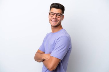 Beyaz arka planda izole edilmiş, kolları çapraz ve ileriye bakan genç beyaz bir adam.