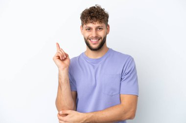 Beyaz arka planda izole edilmiş yakışıklı beyaz adam mutlu ve dik duruyor.