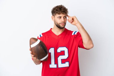 Beyaz arka planda ragbi oynayan Kafkasyalı genç adamın şüpheleri ve düşünceleri var.