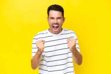 Soyutlanmış sarı arka planda genç yakışıklı bir adam kötü bir durum yüzünden hayal kırıklığına uğradı.