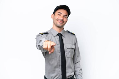 İzole edilmiş beyaz arka plandaki genç güvenlik görevlisi kendine güvenen bir ifadeyle seni işaret ediyor.