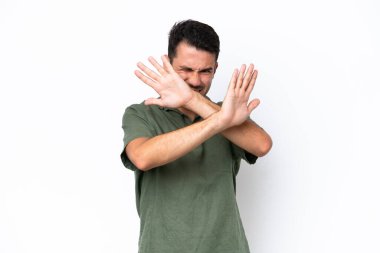 Genç yakışıklı adam soyutlanmış beyaz arka planda gergin ellerini öne uzatıyor.