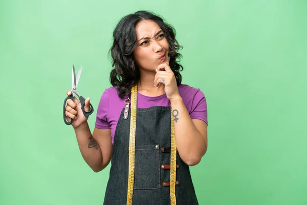 stock image Young seamstress argentinian woman over isolated background having doubts