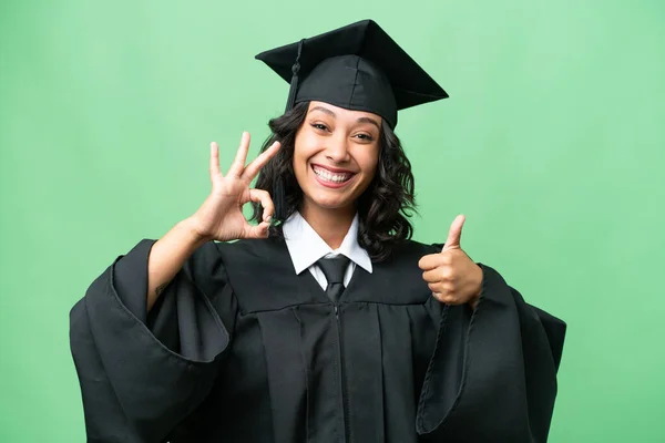 若いです大学卒業アルゼンチン人女性以上孤立した背景ショーOk Signと親指アップジェスチャー — ストック写真