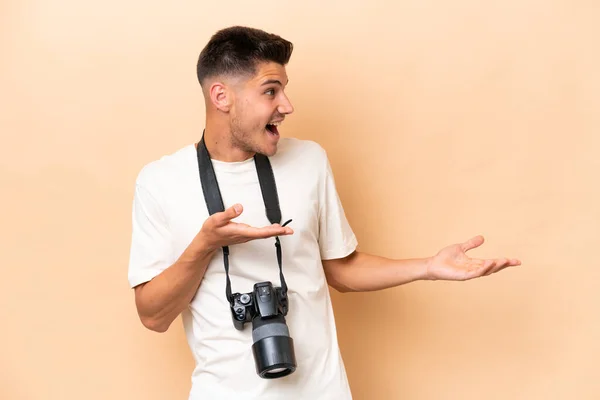 年轻的摄影师高加索男子 因米色背景而被隔离 面部表情惊讶 — 图库照片