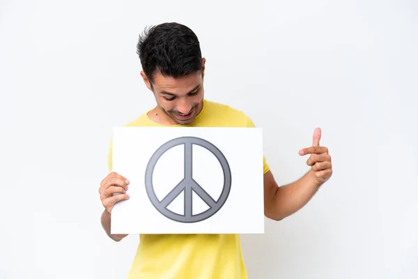Mladý Pohledný Muž Izolovaném Bílém Pozadí Drží Plakát Symbolem Míru — Stock fotografie