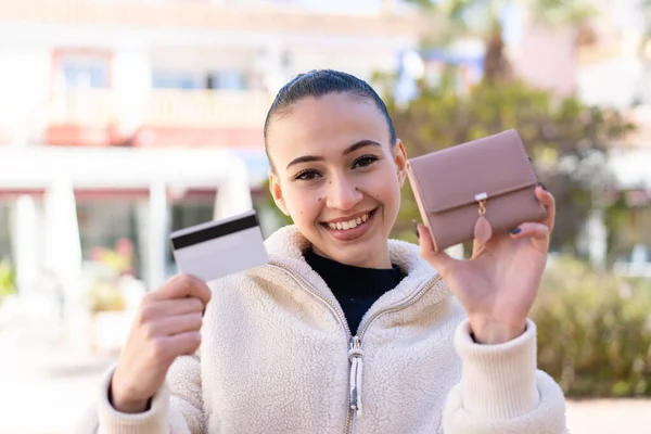 若いですMoroccan女の子に屋外で保持財布とクレジットカードで幸せな表現 — ストック写真