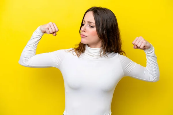 Stock image Young caucasian woman isolated on yellow background doing strong gesture