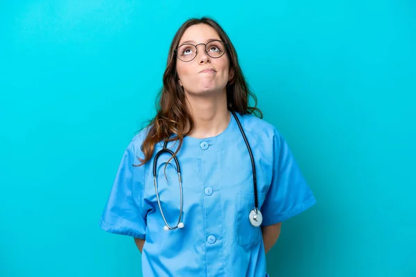 Jonge Chirurg Arts Vrouw Geïsoleerd Blauwe Achtergrond Zoek Omhoog — Stockfoto