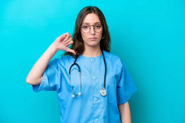 stock image Young surgeon doctor woman isolated on blue background showing thumb down with negative expression