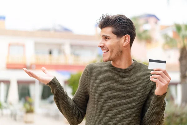 Young Caucasian Man Holding Credit Card Outdoors Surprise Facial Expression — Stock Photo, Image