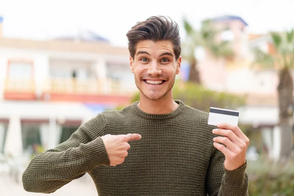 Young Caucasian Man Holding Credit Card Outdoors Surprise Facial Expression — Stock Photo, Image