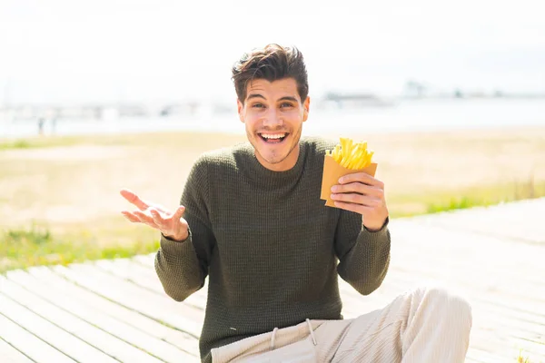 Joven Hombre Caucásico Sosteniendo Chips Fritos Aire Libre Con Expresión —  Fotos de Stock