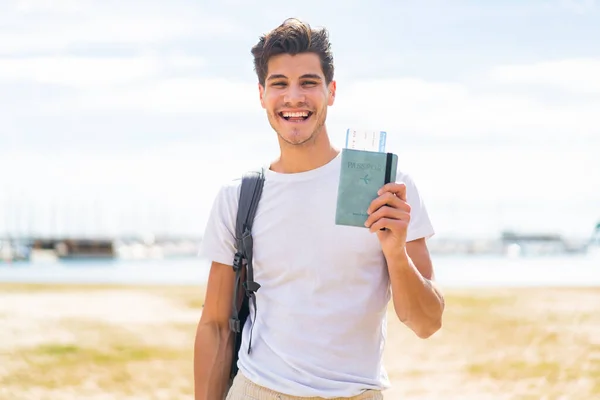 Jonge Blanke Man Met Een Paspoort Buitenlucht Die Veel Glimlacht — Stockfoto