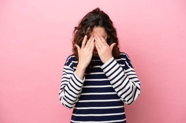 Pembe arka planda izole edilmiş, yorgun ve hasta bir yüzü olan beyaz bir kadın.